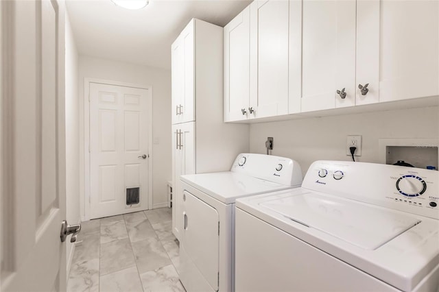 laundry room with washing machine and dryer and cabinets