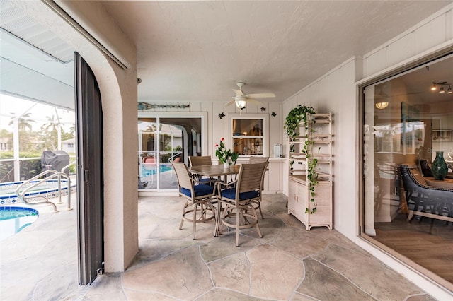 view of patio featuring glass enclosure and ceiling fan