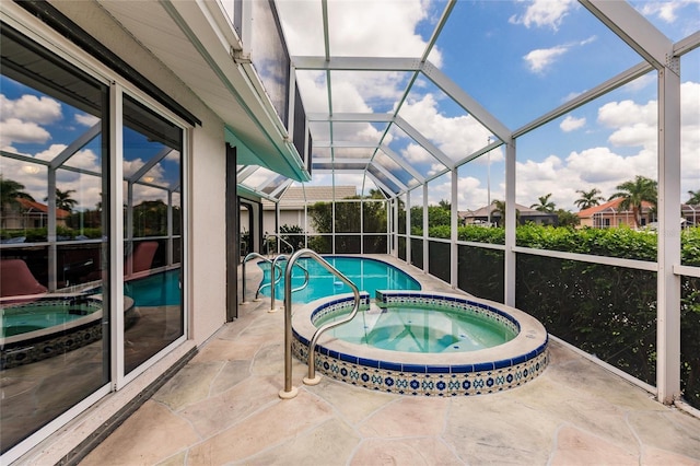 view of swimming pool featuring a patio area, a lanai, and an in ground hot tub