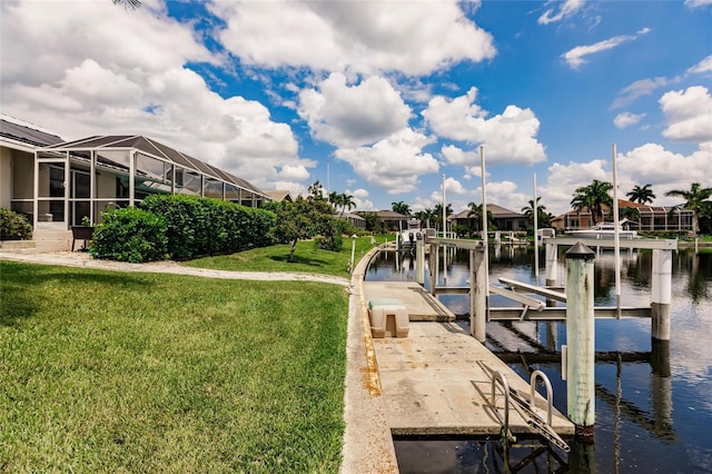 dock area featuring a lanai, a yard, and a water view