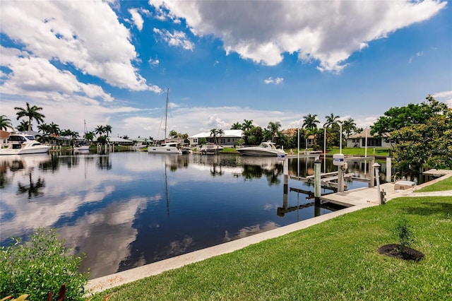 view of dock with a water view and a lawn