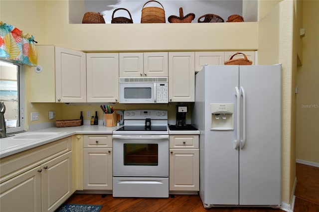 kitchen with white cabinetry, dark hardwood / wood-style flooring, sink, and white appliances