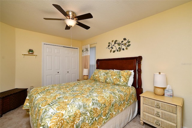 carpeted bedroom featuring ceiling fan, a textured ceiling, and a closet