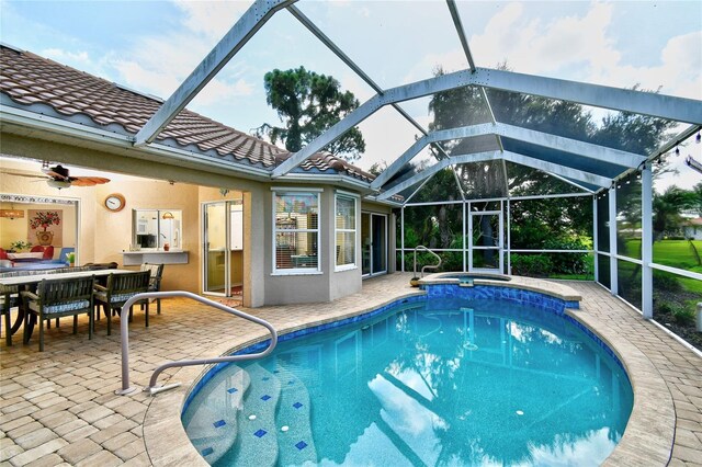 view of pool featuring a patio area, ceiling fan, and glass enclosure