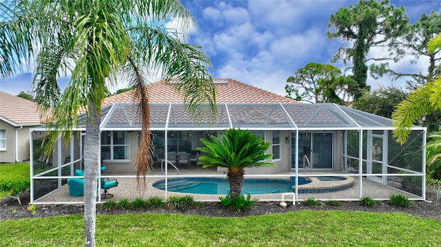 rear view of property with a yard, a lanai, and a patio area