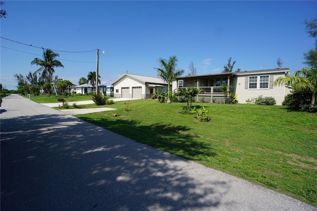 single story home with a porch, a front yard, and a garage