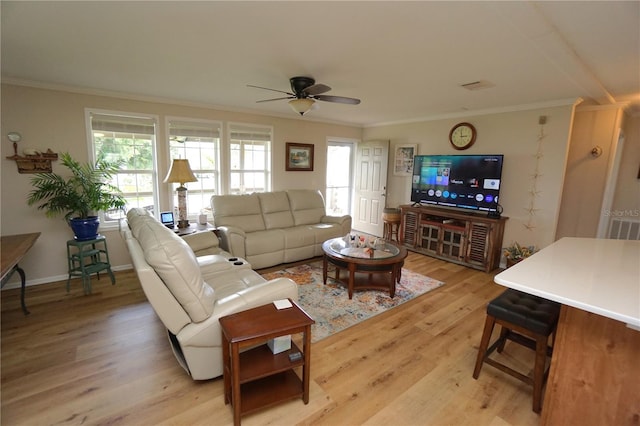 living room featuring ceiling fan, ornamental molding, and light hardwood / wood-style flooring