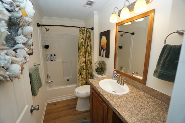 full bathroom featuring toilet, hardwood / wood-style flooring, shower / bath combo with shower curtain, vanity, and ornamental molding