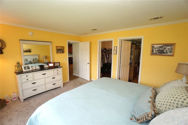 carpeted bedroom with a spacious closet, ornamental molding, and a closet