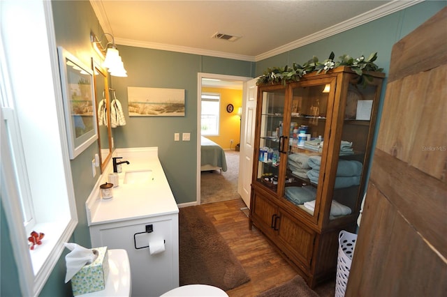 bathroom featuring hardwood / wood-style flooring, vanity, and crown molding