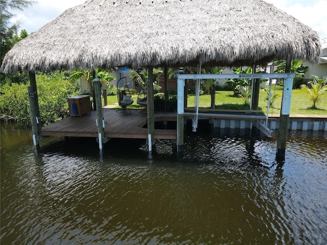 dock area with a gazebo, a water view, and a yard