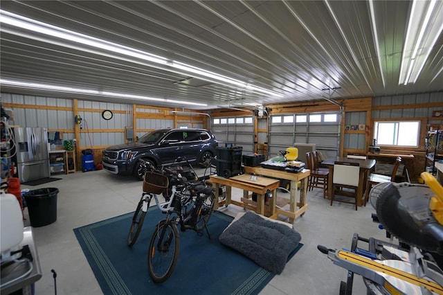 garage featuring stainless steel fridge and a garage door opener