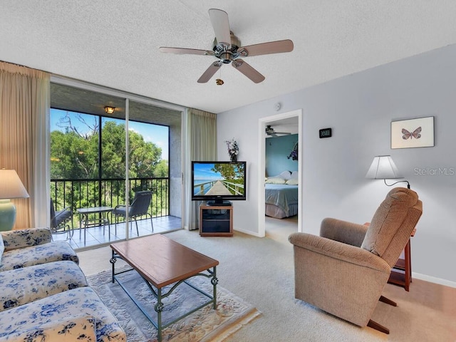 living room with expansive windows, ceiling fan, light carpet, and a textured ceiling