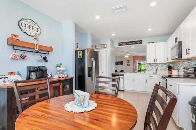 dining room featuring ceiling fan, light tile patterned flooring, and sink