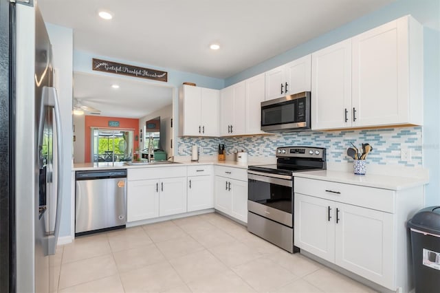 kitchen featuring white cabinets, decorative backsplash, stainless steel appliances, and ceiling fan