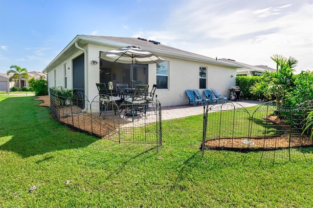 back of house with a patio and a lawn