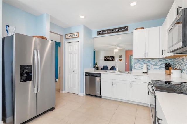 kitchen featuring decorative backsplash, appliances with stainless steel finishes, ceiling fan, sink, and white cabinetry