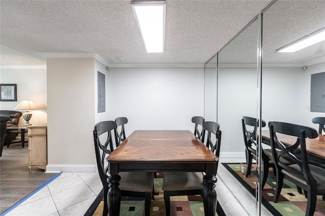 tiled dining area featuring ornamental molding, a textured ceiling, and electric panel