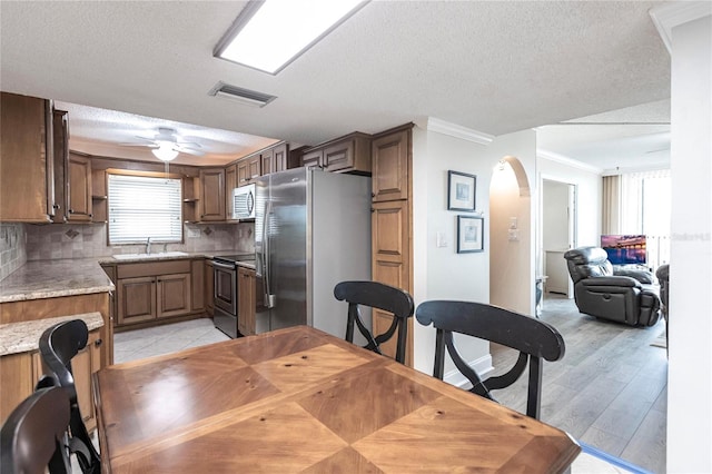 dining space featuring light hardwood / wood-style floors, crown molding, plenty of natural light, and ceiling fan