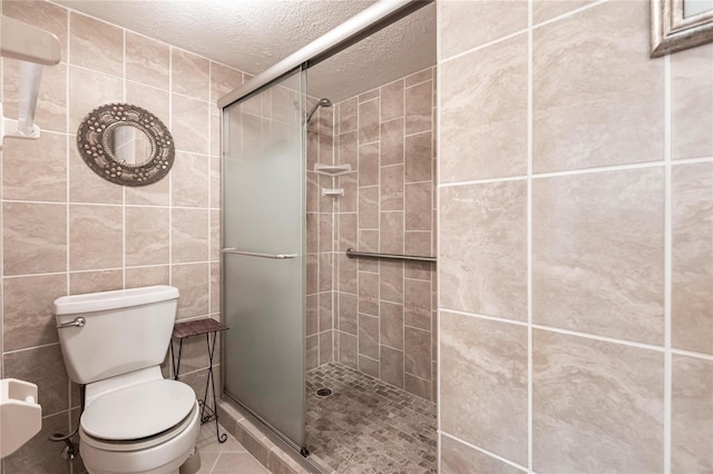 bathroom featuring toilet, an enclosed shower, tile walls, tile patterned floors, and a textured ceiling