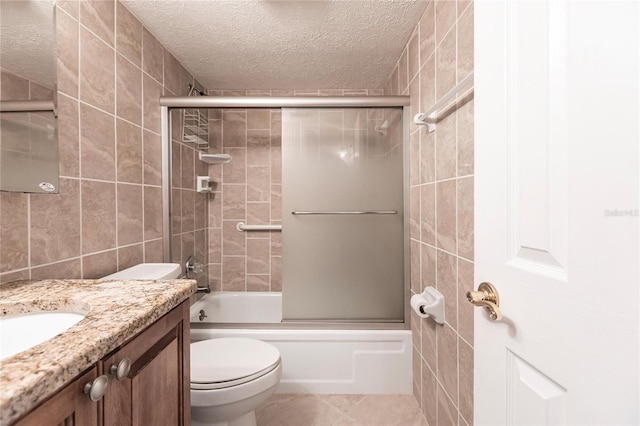 full bathroom featuring enclosed tub / shower combo, toilet, tile patterned flooring, vanity, and tile walls