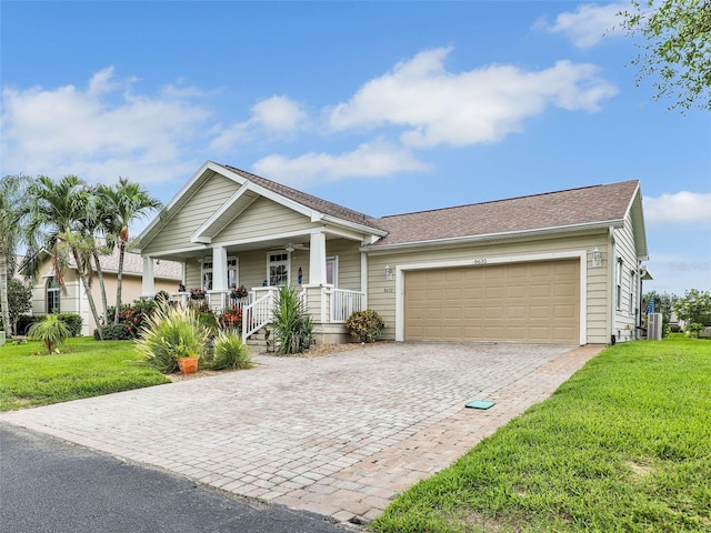 craftsman house with covered porch, a front lawn, and a garage