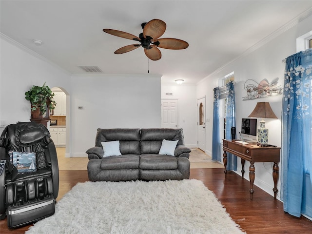 living room featuring ceiling fan, dark wood-type flooring, and crown molding