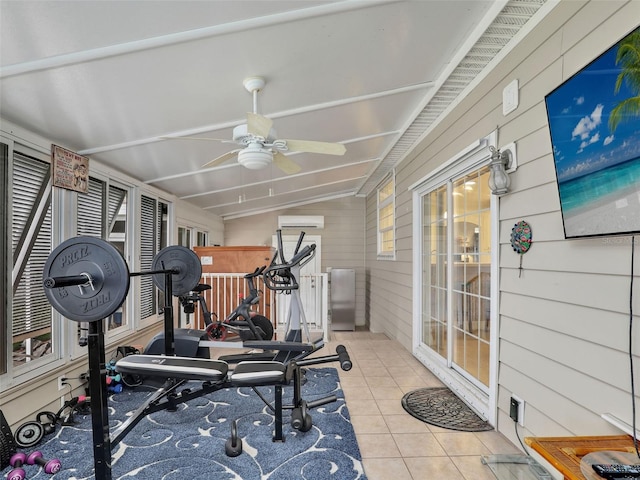 workout room featuring a wall unit AC, ceiling fan, light tile patterned flooring, wooden walls, and lofted ceiling