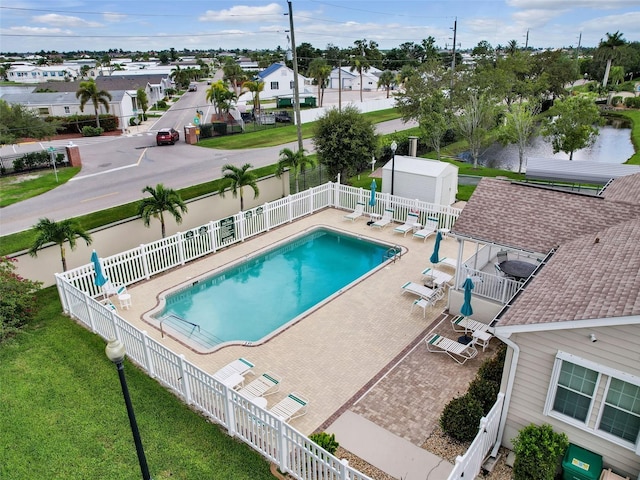 view of pool with a patio, a storage shed, and a yard