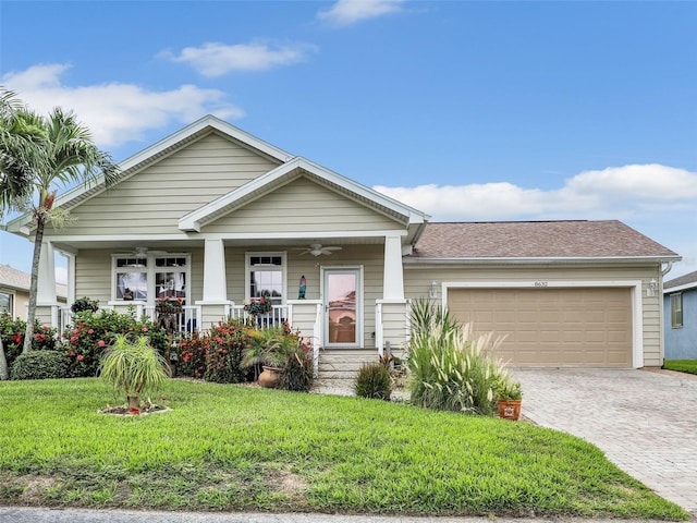view of front of home featuring a garage, decorative driveway, a front yard, ceiling fan, and a porch