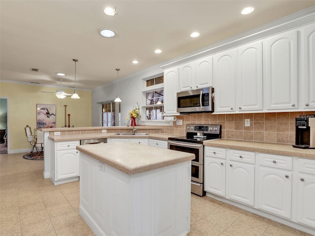 kitchen with a sink, a peninsula, tasteful backsplash, and appliances with stainless steel finishes