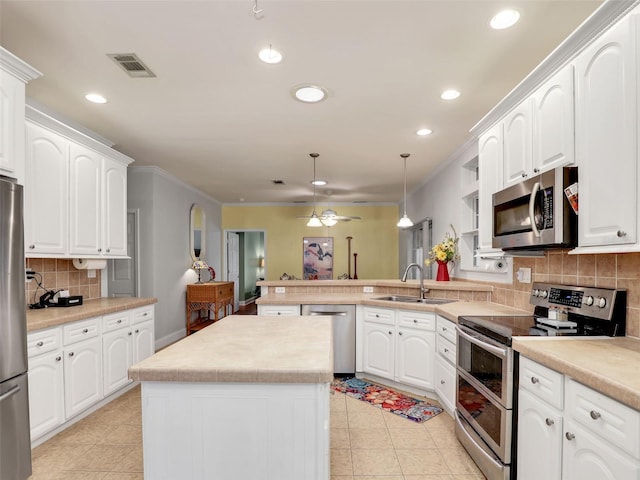 kitchen with a sink, a peninsula, stainless steel appliances, and recessed lighting