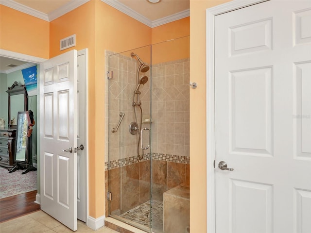 full bathroom featuring a stall shower, crown molding, visible vents, and baseboards
