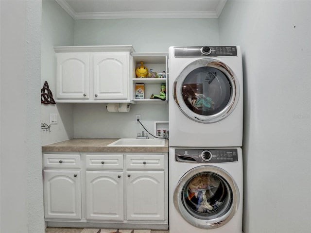clothes washing area with cabinet space, crown molding, stacked washing maching and dryer, and a sink
