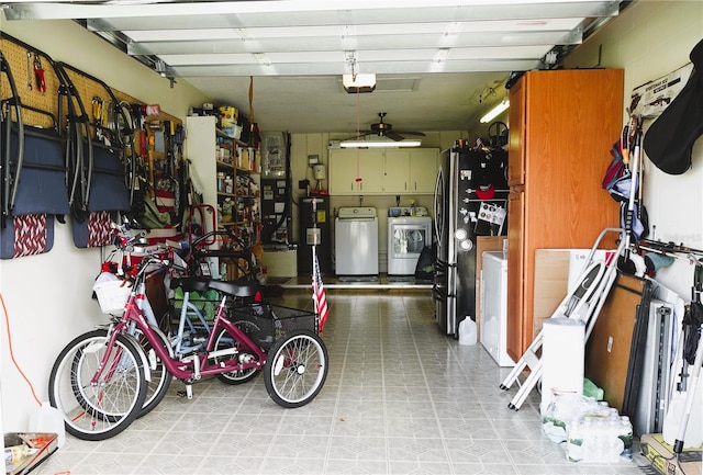 garage with stainless steel fridge, a garage door opener, and washer and dryer