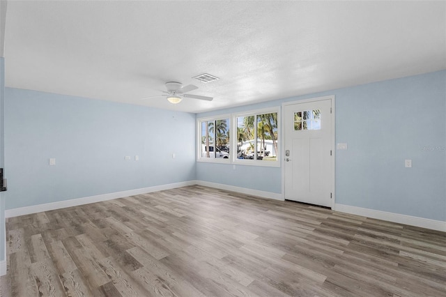 spare room featuring a textured ceiling, ceiling fan, and light hardwood / wood-style flooring