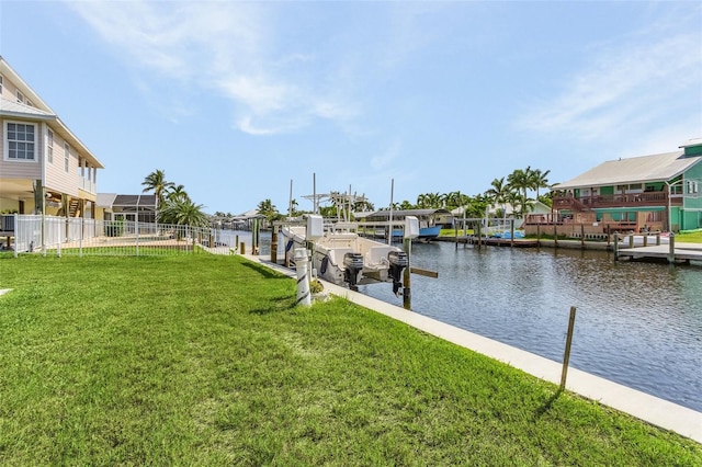 view of dock with a yard and a water view