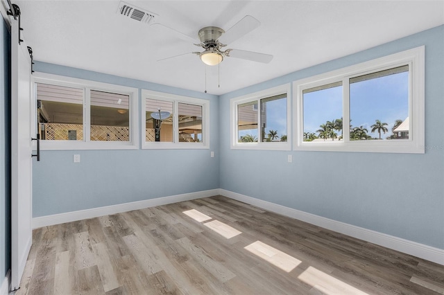 spare room featuring ceiling fan, a healthy amount of sunlight, and light hardwood / wood-style floors