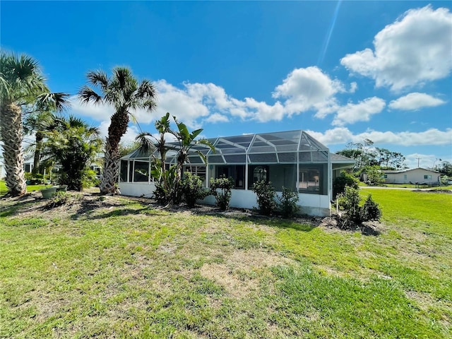 rear view of property featuring a yard and a lanai