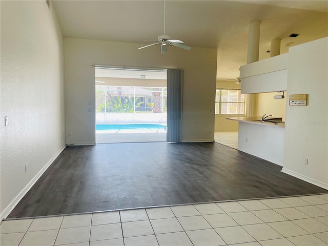 unfurnished living room featuring ceiling fan and light tile patterned flooring