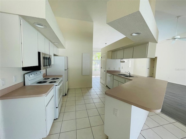 kitchen with white appliances, sink, ceiling fan, light tile patterned floors, and kitchen peninsula