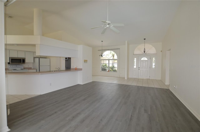 515 Allworthy St, Port Charlotte, FL 33954 - unfurnished living room with ceiling fan, high vaulted ceiling, wood finished floors, a sink, and baseboards