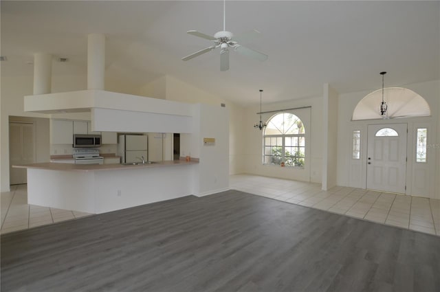 515 Allworthy St, Port Charlotte, FL 33954 - unfurnished living room with high vaulted ceiling, light wood finished floors, ceiling fan with notable chandelier, and a sink