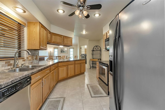 kitchen featuring ceiling fan, sink, light tile patterned flooring, decorative backsplash, and stainless steel appliances