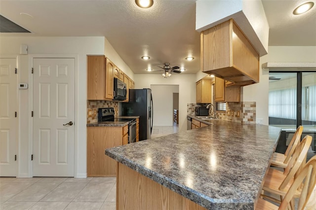 kitchen with ceiling fan, decorative backsplash, appliances with stainless steel finishes, and kitchen peninsula