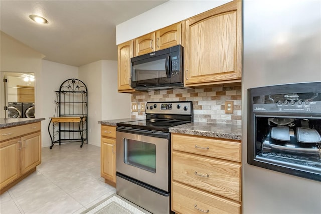 kitchen featuring washing machine and dryer, stainless steel appliances, decorative backsplash, and light brown cabinets