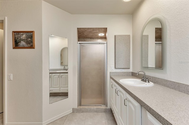 bathroom with a shower with door, tile patterned floors, and vanity