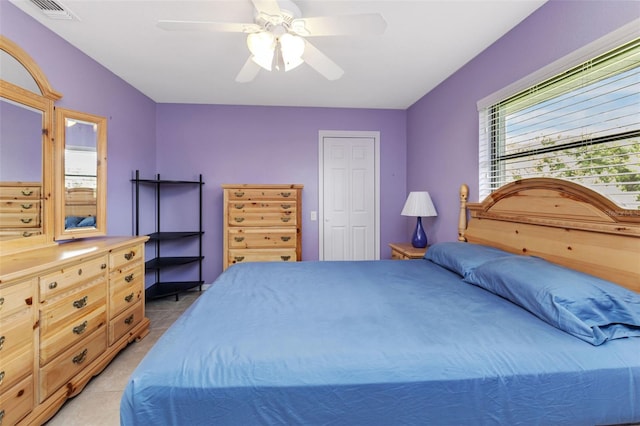 bedroom with ceiling fan, light tile patterned floors, and a closet