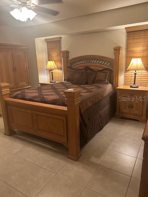 bedroom with ceiling fan and light tile patterned floors