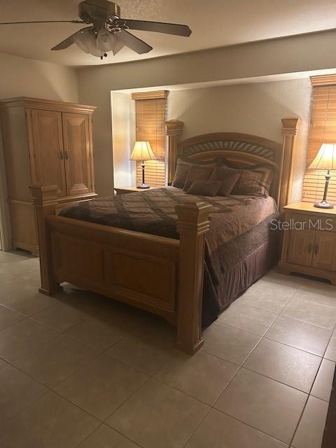 tiled bedroom with ceiling fan